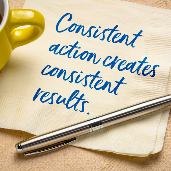 piece of paper with the quote "consistent action creates consistent results"