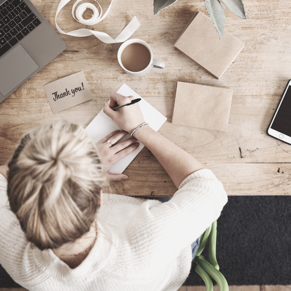 woman writing a personal note to her customer